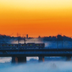 都会の川霧を住く列車